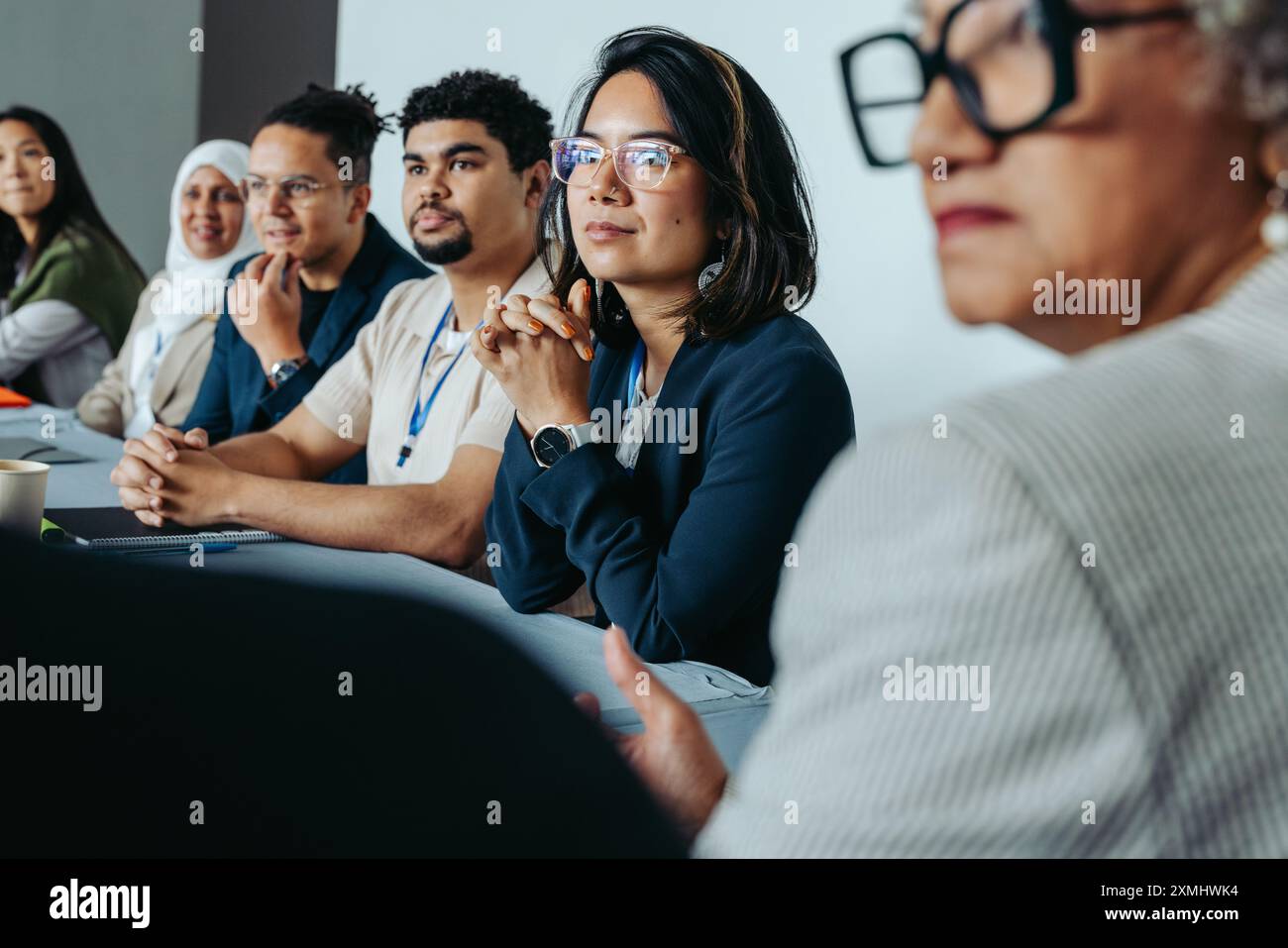 Un groupe diversifié de professionnels dans une réunion de conseil d'administration, concentré et attentif, suggérant collaboration et travail d'équipe. Banque D'Images