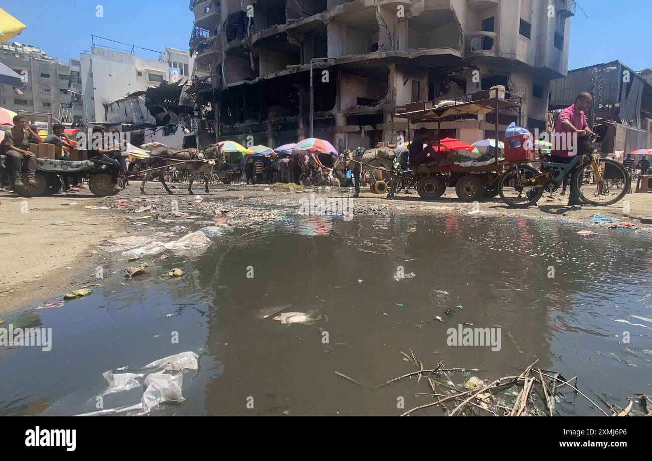 Les Palestiniens marchent près d’une rue couverte d’eaux usées stagnantes dans la ville de Gaza les Palestiniens marchent près d’une rue couverte d’eaux usées stagnantes dans la ville de Gaza, le 28 juillet 2024. La polio a été détectée dans des échantillons d'eaux usées qui commencent à s'emparer de Gaza en proie à une guerre dévastatrice, ont déclaré les autorités sanitaires du territoire dirigé par le Hamas et Israël le 18 juillet, où des milliers de personnes vivent dans des villes de tentes surpeuplées de déplacés de guerre. Photo de Hadi Daoud apaimages ville de Gaza bande de Gaza territoire palestinien 280724 Gaza HD 005 Copyright : xapaimagesxHadixDaoudxxapaimagesx Banque D'Images