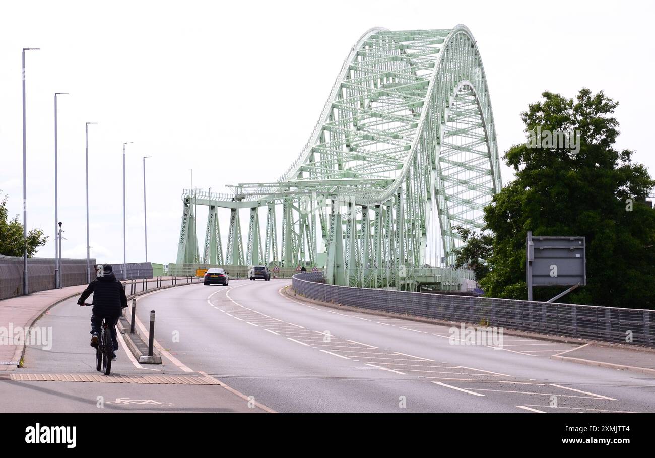 Cheshire, Royaume-Uni, 28 juillet 2024. Juillet se termine chaud dans la région de Widnes Runcorn dans le Cheshire Royaume-Uni, avec une température atteignant 25C. Un cycliste et des voitures sur le pont Silver Jubilee qui relie Widnes à Runcorn. Crédit : Terry Waller/Alamy Live News Banque D'Images