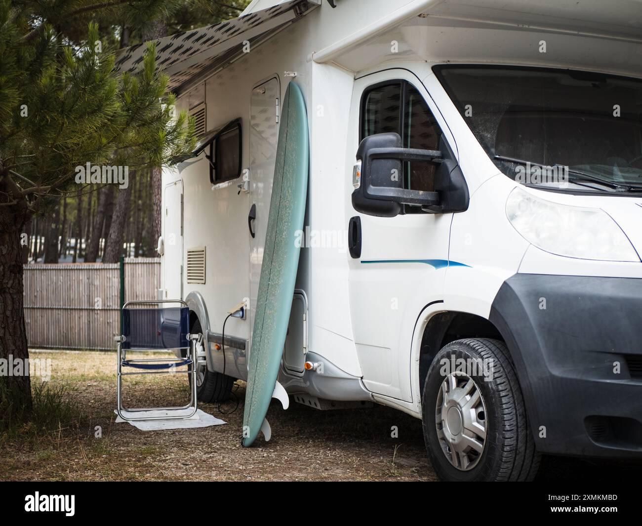 Camping-car dans le camping, une chaise et une planche de surf sont à l'extérieur Banque D'Images