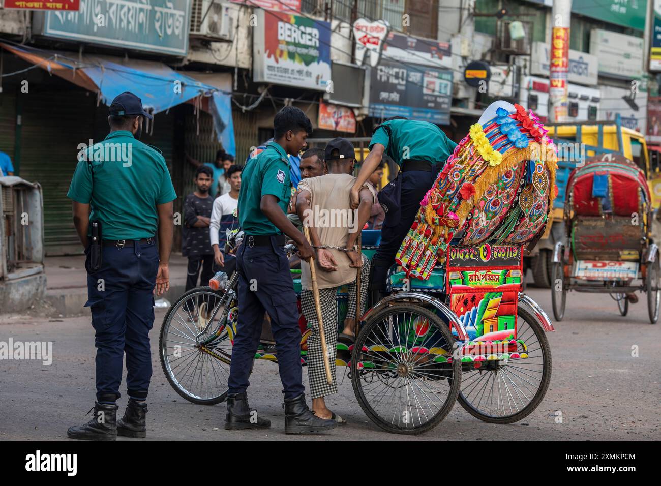 La police du Bangladesh arrête un résident pendant un couvre-feu national le gouvernement du Bangladesh a décrété un couvre-feu dans tout le pays pour une durée indéterminée et a déployé une armée pour aider l'administration civile. Banque D'Images