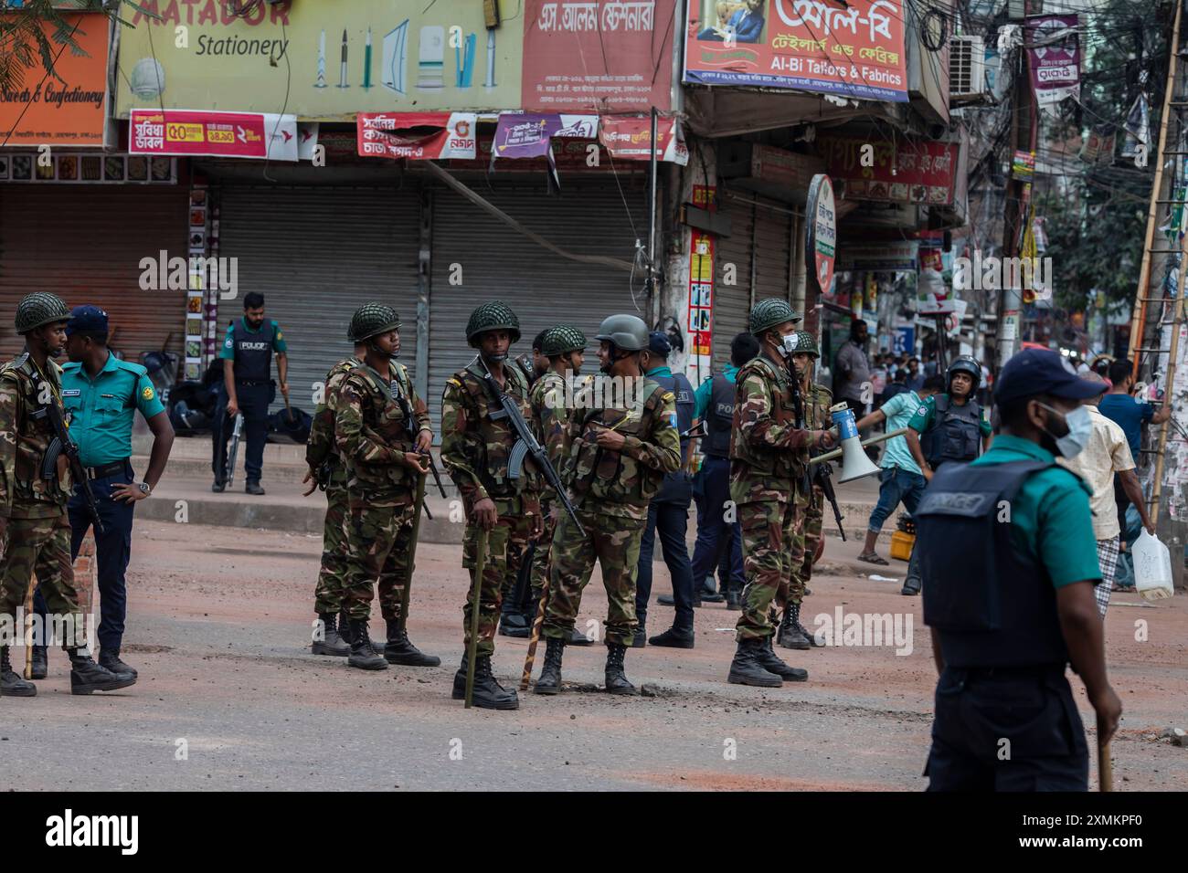 Les soldats des forces militaires bangladaises, les gardes-frontières du Bangladesh (BGB) et la police du Bangladesh restent en alerte dans la région de Mohammadpur pendant un couvre-feu national. Le gouvernement du Bangladesh a décrété un couvre-feu dans tout le pays pour une durée indéterminée et a déployé une armée pour aider l'administration civile. Banque D'Images