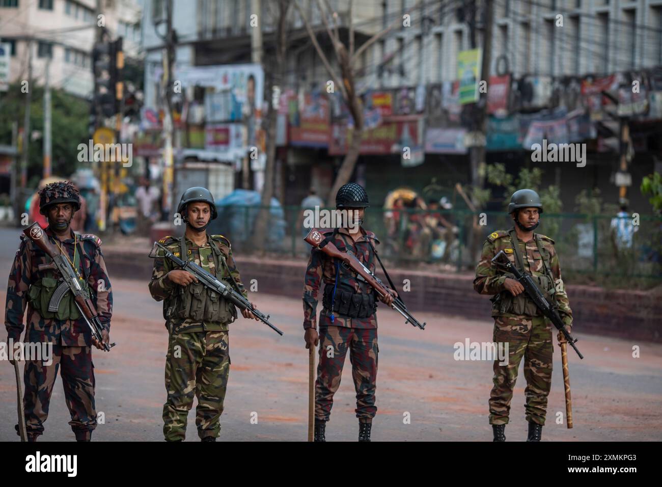 Les soldats des forces militaires bangladaises, les gardes-frontières du Bangladesh (BGB) et la police du Bangladesh restent en alerte dans la région de Mohammadpur pendant un couvre-feu national. Le gouvernement du Bangladesh a décrété un couvre-feu dans tout le pays pour une durée indéterminée et a déployé une armée pour aider l'administration civile. Banque D'Images