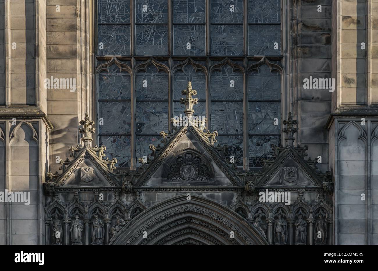 Édimbourg, Écosse - 18 janvier 2024 - le soleil brille à travers la surface des vitraux arqués et le pignon se trouve au-dessus de la porte d'entrée de St. Banque D'Images