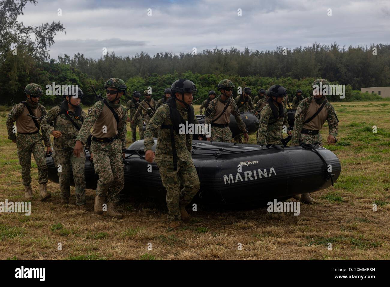 Les Marines du corps d'infanterie navale mexicain, aux côtés des soldats malaisiens affectés au 8e bataillon (parachute), du Royal Ranger Regiment, de la 10e brigade de parachutistes, travaillent ensemble pour transporter des engins de combat de raids en caoutchouc dans la zone d'entraînement du corps des Marines Bellows, Waimanalo, Hawaï, lors de l'exercice Rim of the Pacific 2024, le 12 juillet. Vingt-neuf pays, 40 navires de surface, trois sous-marins, 14 forces terrestres nationales, plus de 150 avions et 25 000 membres du personnel participent au RIMPAC dans et autour des îles Hawaï, du 27 juin au 1er août. Le RIMPAC, le plus grand exercice maritime international au monde, offre un t unique Banque D'Images