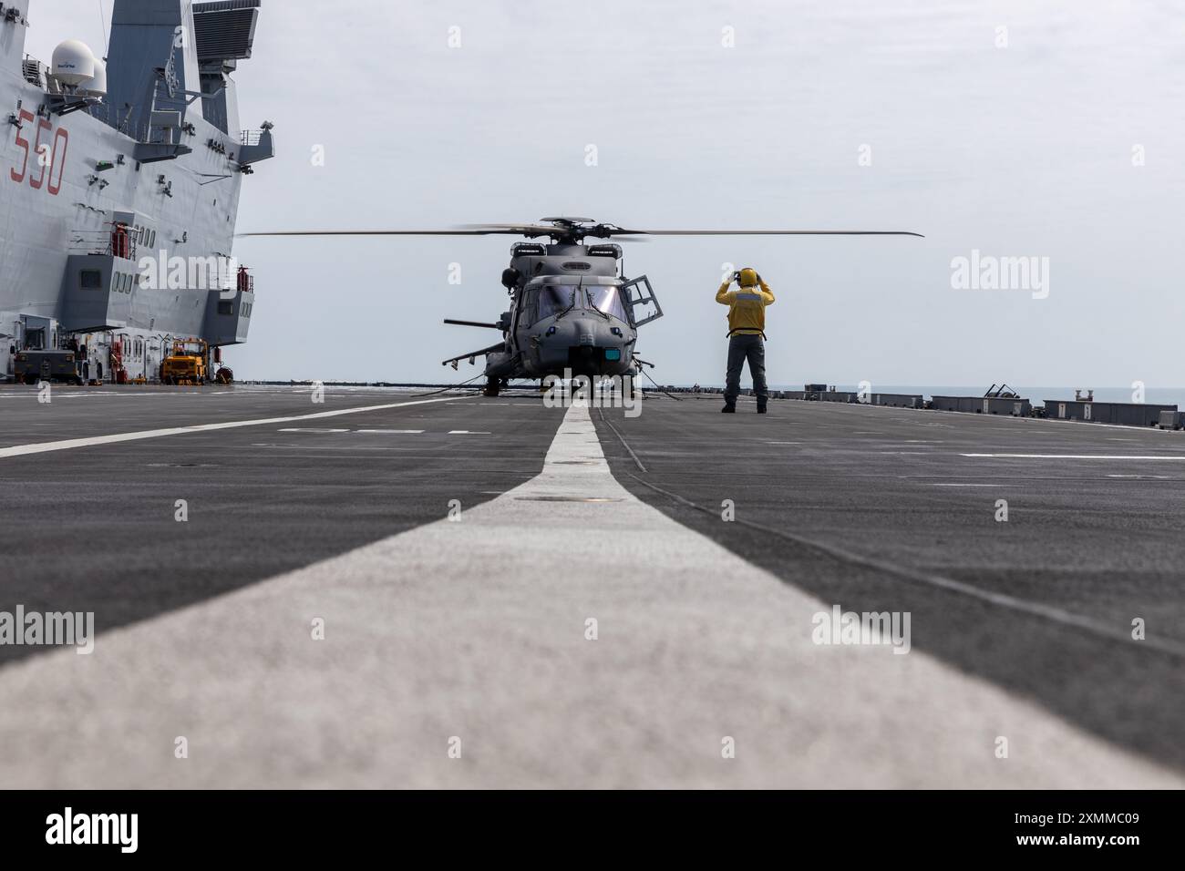 Un matelot de la marine italienne sécurise un NH-90 de la marine italienne sur le pont d'atterrissage du porte-avions italien ITS Cavour lors de l'exercice Pitch Black 24, dans la mer de Timor, le 25 juillet 2024. L’exercice Pitch Black 24 est le plus important des 43 ans d’histoire de l’exercice et rassemble 20 pays participants, plus de 140 avions du monde entier et plus de 4000 membres du personnel. L'emplacement de l'exercice Black 24 permet à Marine Rotational Force - l'élément de combat aérien de Darwin 24.3 (Marine Medium Tiltrotor Squadron 268 (renforcé), d'intégrer les MV-22B Ospreys et les capacités de combat aérien dans un cadre mixte Banque D'Images