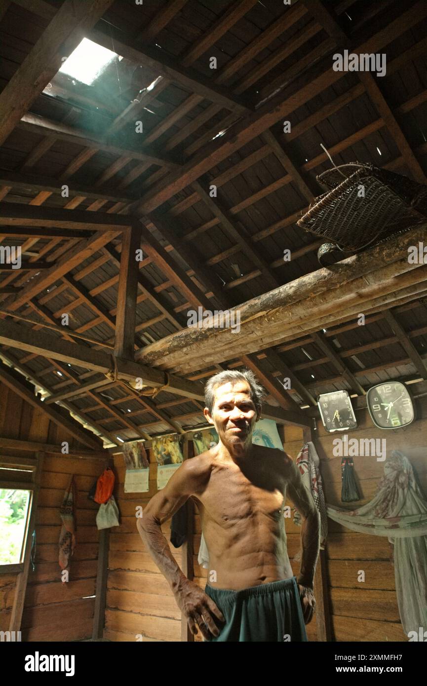 Portrait de Daniel Rajang, ancien tumenggung (chef traditionnel) de la communauté Orung Da'an Dayak, dans sa cabane agricole du village de Nanga Raun, Kalis, Kapuas Hulu, Kalimantan occidental, Indonésie. La communauté Orung Da'an avait autrefois la plus longue maison longue de Kalimantan, mais elle a disparu après un accident d'incendie il y a quelques décennies, a-t-il dit. Banque D'Images