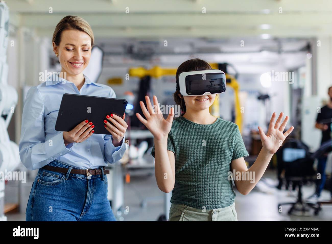 Écolière apprenant avec casque VR sur la tête. Enseignant utilisant la technologie moderne, réalité virtuelle en classe, leçon. Banque D'Images