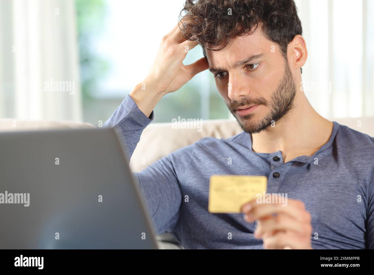 Homme inquiet achetant en ligne avec carte de crédit et ordinateur portable se plaignant à la maison Banque D'Images