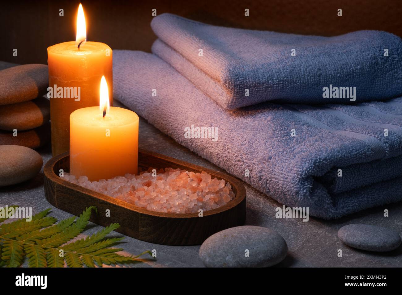 Composition de spa avec des bougies, du sel de mer et des serviettes sur fond gris Banque D'Images