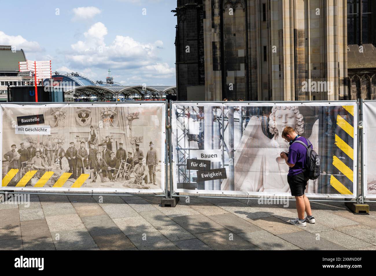 Homme devant une clôture de chantier à la cathédrale, image d'une figure de façade de la cathédrale, Cologne, Allemagne. ***USAGE ÉDITORIAL EXCLUSIF*** MAN Banque D'Images