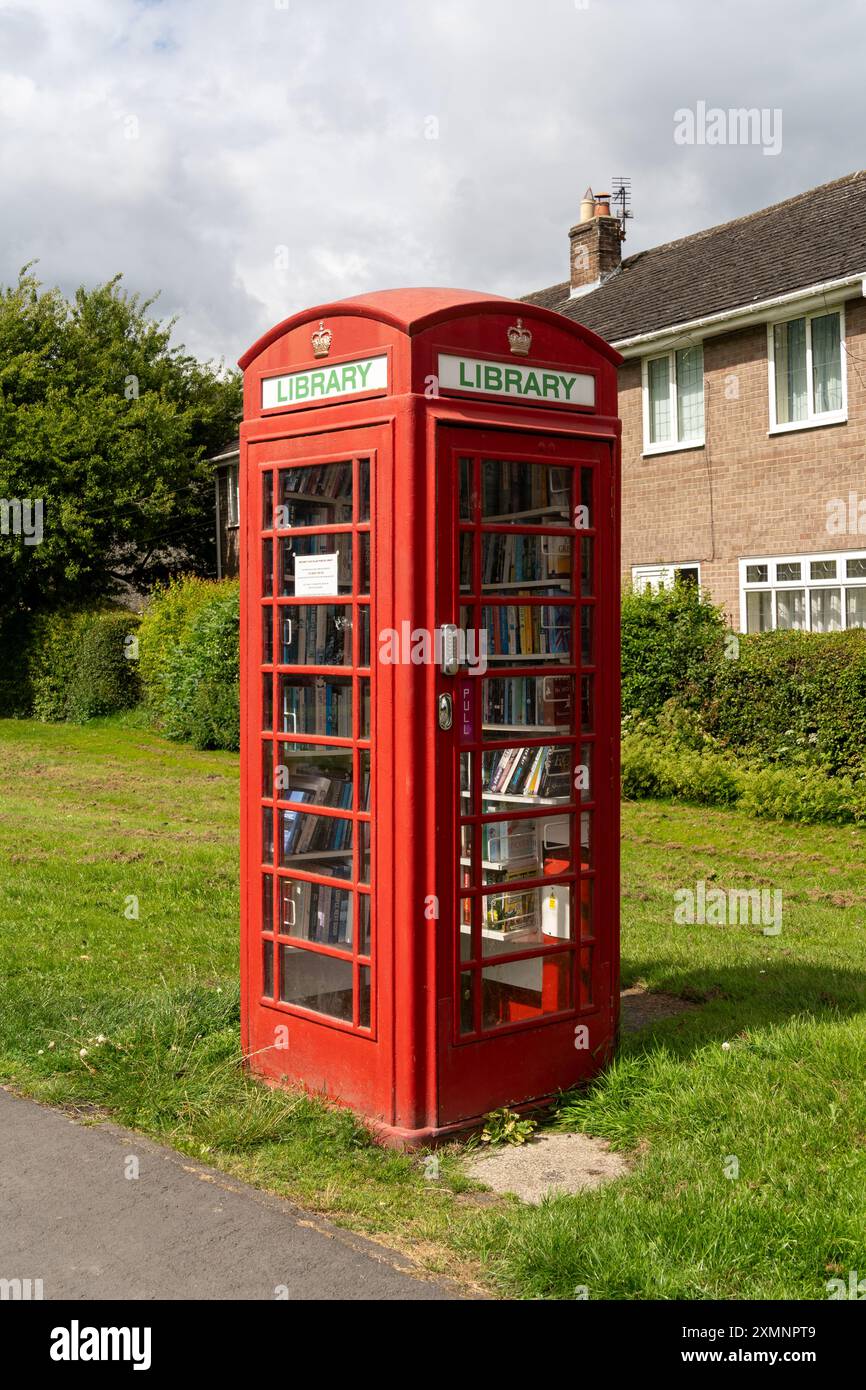 Village de Tudhoe, NR. Comté de Spennymoor Durham, Royaume-Uni. Boîte téléphonique rouge vintage convertie ou upcyclée en bibliothèque locale. Banque D'Images