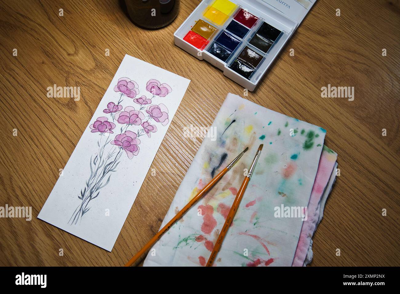 Un espace de travail d'artiste accueillant avec une peinture à l'aquarelle vibrante de fleurs en cours. Illustration, créativité, techniques artistiques, artistiques. Banque D'Images