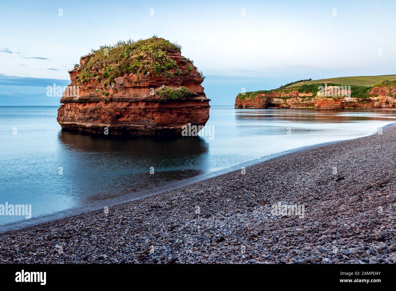 Un empilement de grès dans la baie de Ladram près de Sidmouth dans le sud-est du Devon, capturé au lever du soleil en juillet. Banque D'Images