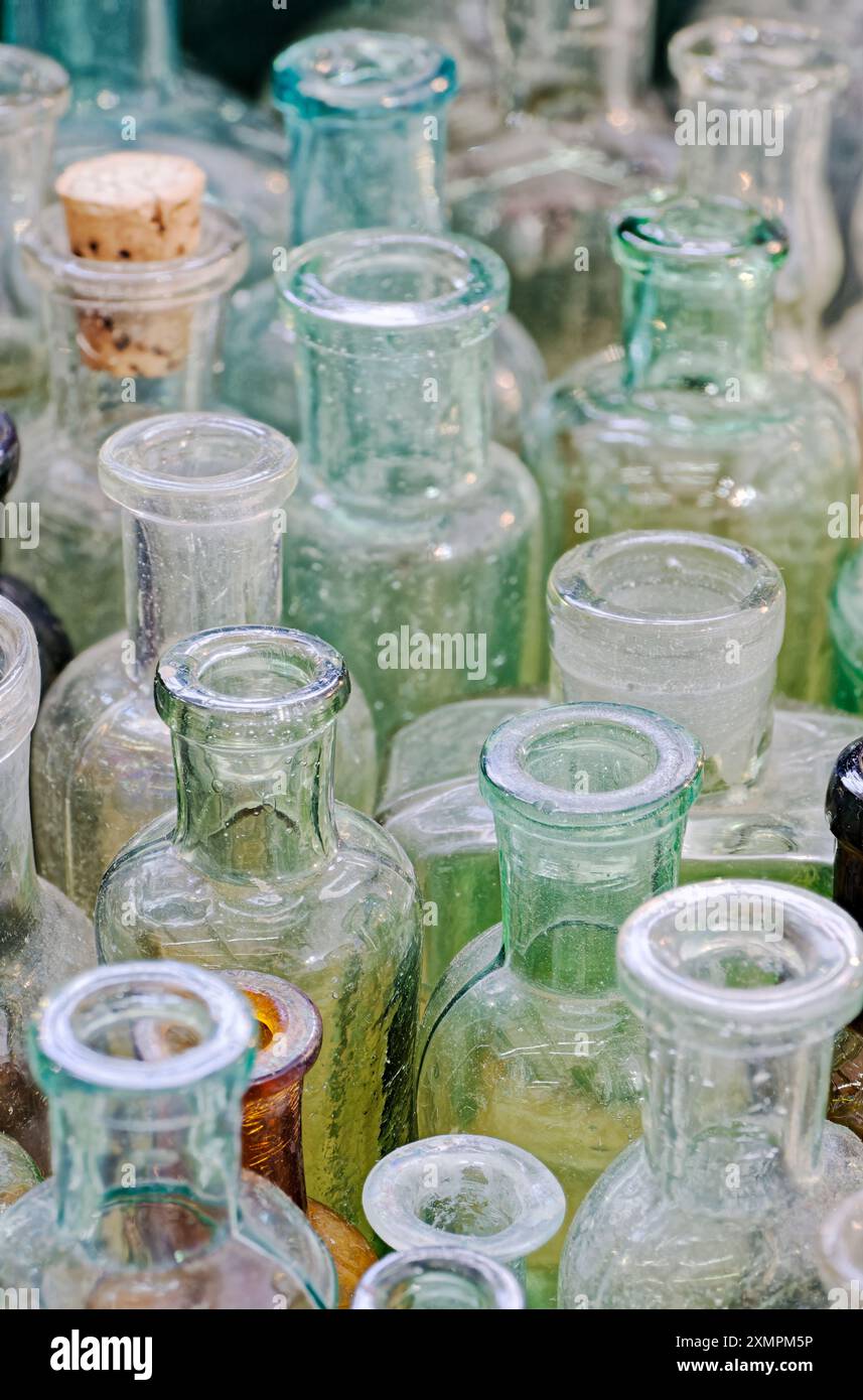 Grand groupe de petites bouteilles en verre vides, vieillies et poussiéreuses. Fond vintage abstrait. Banque D'Images