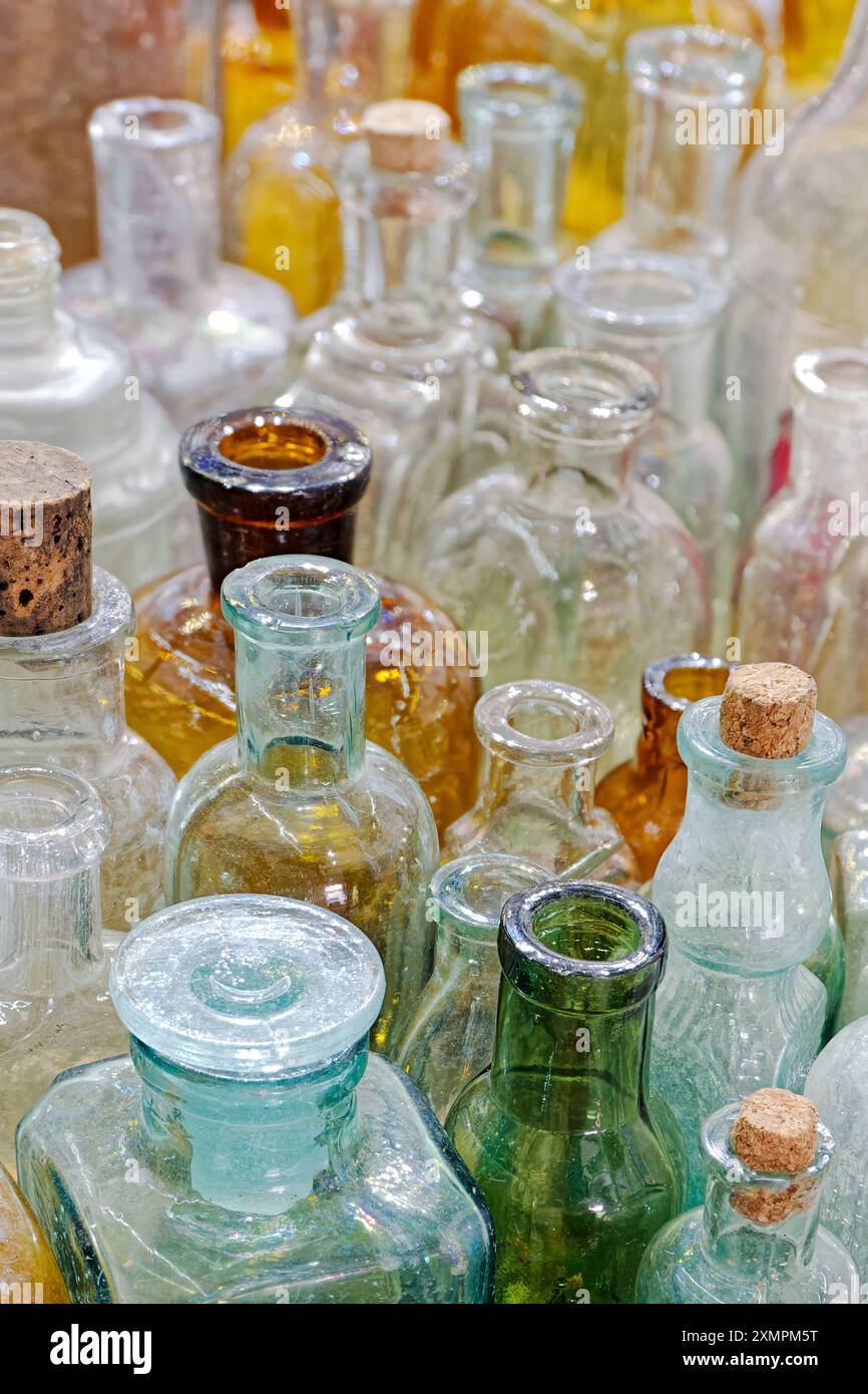 Grand groupe de petites bouteilles en verre vides, vieillies et poussiéreuses. Fond vintage abstrait. Banque D'Images
