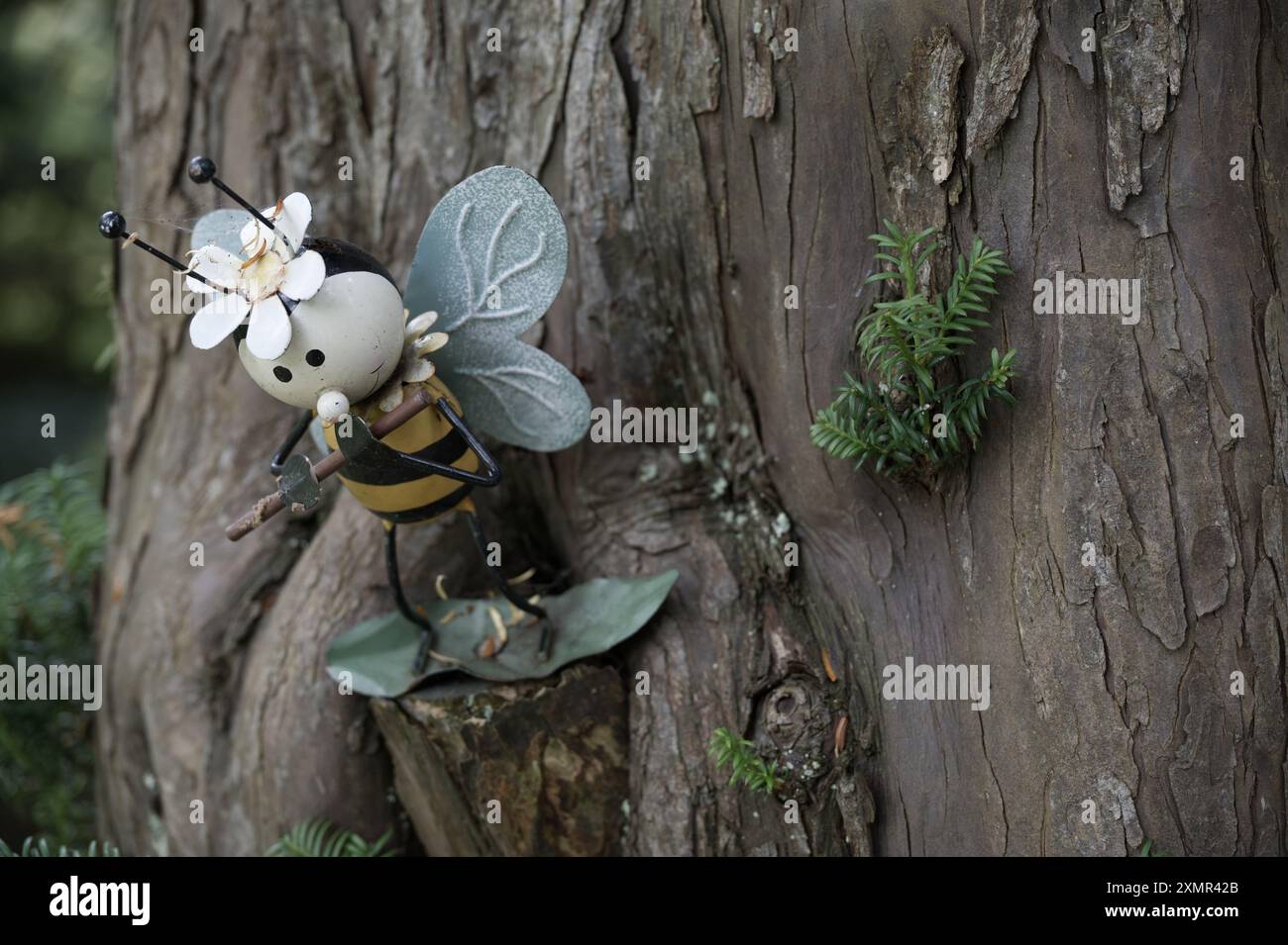 Une petite sculpture d'une abeille jouant de la flûte sur le flanc d'un arbre Banque D'Images