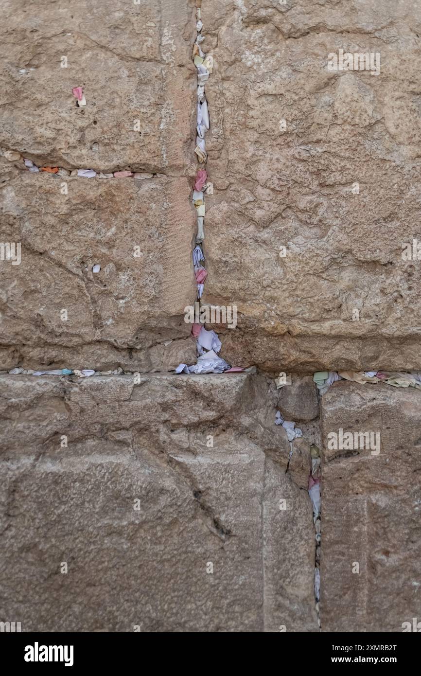 Jérusalem, Israël. 26 juillet 2024. Notes de papier avec bénédictions et prières à l'intérieur des fissures du mur occidental. Le mur occidental, également connu sous le nom de mur des lamentations à l'Ouest et mur d'Al Buraq dans l'Islam, est une destination de pèlerinage pour les croyants juifs. Situé dans la vieille ville de Jérusalem, il fait partie du mur de soutènement du Mont du Temple. Une cloison métallique divise la zone en deux : les hommes à gauche et les femmes à droite. Tout au long de la journée, les croyants juifs visitent le site pour prier, lire les livres sacrés de la Torah et laisser une note de papier à l'intérieur des fissures du mur. Toute la zone est surveillée par les Israéliens Banque D'Images