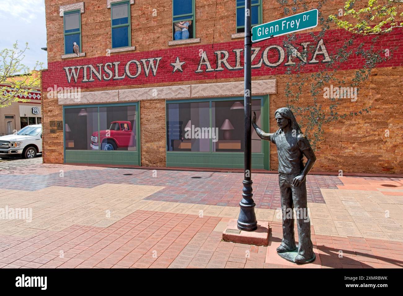 La statue de bronze de Glen Frey se tient près du poteau de lampadaire étiqueté avec un panneau de rue l'honorant au stand' sur le Corner Park - Winslow AZ, avril 2024 Banque D'Images