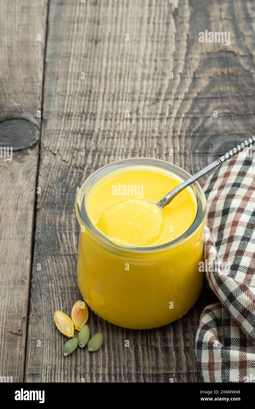 Purée de citrouille dans un pot en verre sur une table en bois Banque D'Images