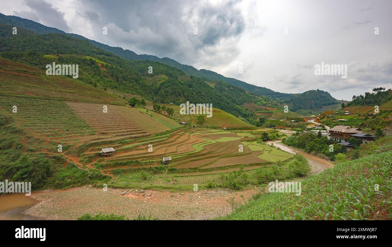 Paysage irrigué avec des reflets du soleil et des champs en terrasses de riz vert et ciel nuageux bleu près de Mu Cang Chai, province de Yen Bai, Nord-Vietnam Banque D'Images