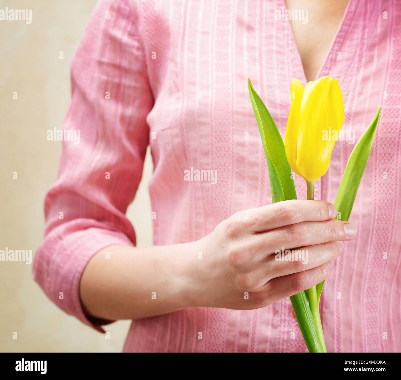 Jeune femme tenant une fleur de tulipe Banque D'Images