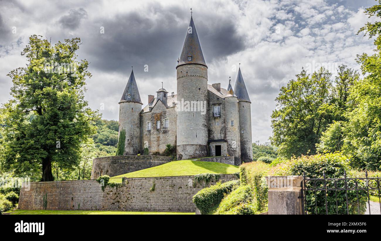 Château de Veves sur la colline avec ciel gris orageux en arrière-plan, entouré d'arbres verdoyants, bâtiment en pierre avec ses tours aux toits coniques, journée ensoleillée Banque D'Images