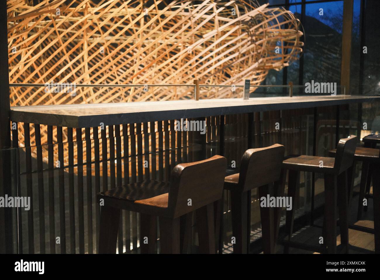 Kuta, Bali, Indonésie - 10 juillet 2024 : décoration d'intérieur avec un bar de table en granit et des tabourets en bois, complétés par un grand décor traditionnel Banque D'Images