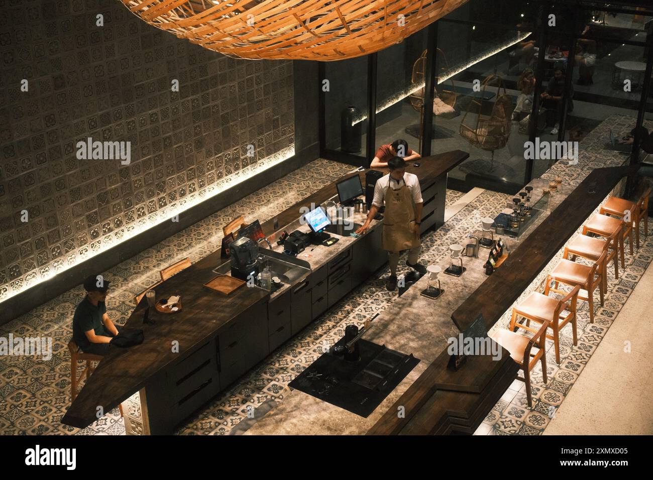 Kuta, Bali, Indonésie - 10 juillet 2024 : décoration intérieure de bar café avec un bar de table en granit et des tabourets en bois, complétés par un bambou Banque D'Images