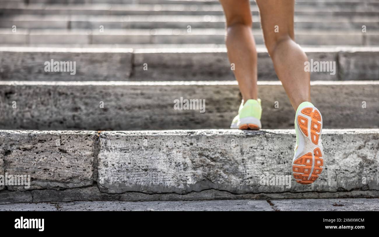 Coureur athlète jambes courir sur les escaliers de la ville. femme fitness jogging entraînement concept de bien-être. Banque D'Images