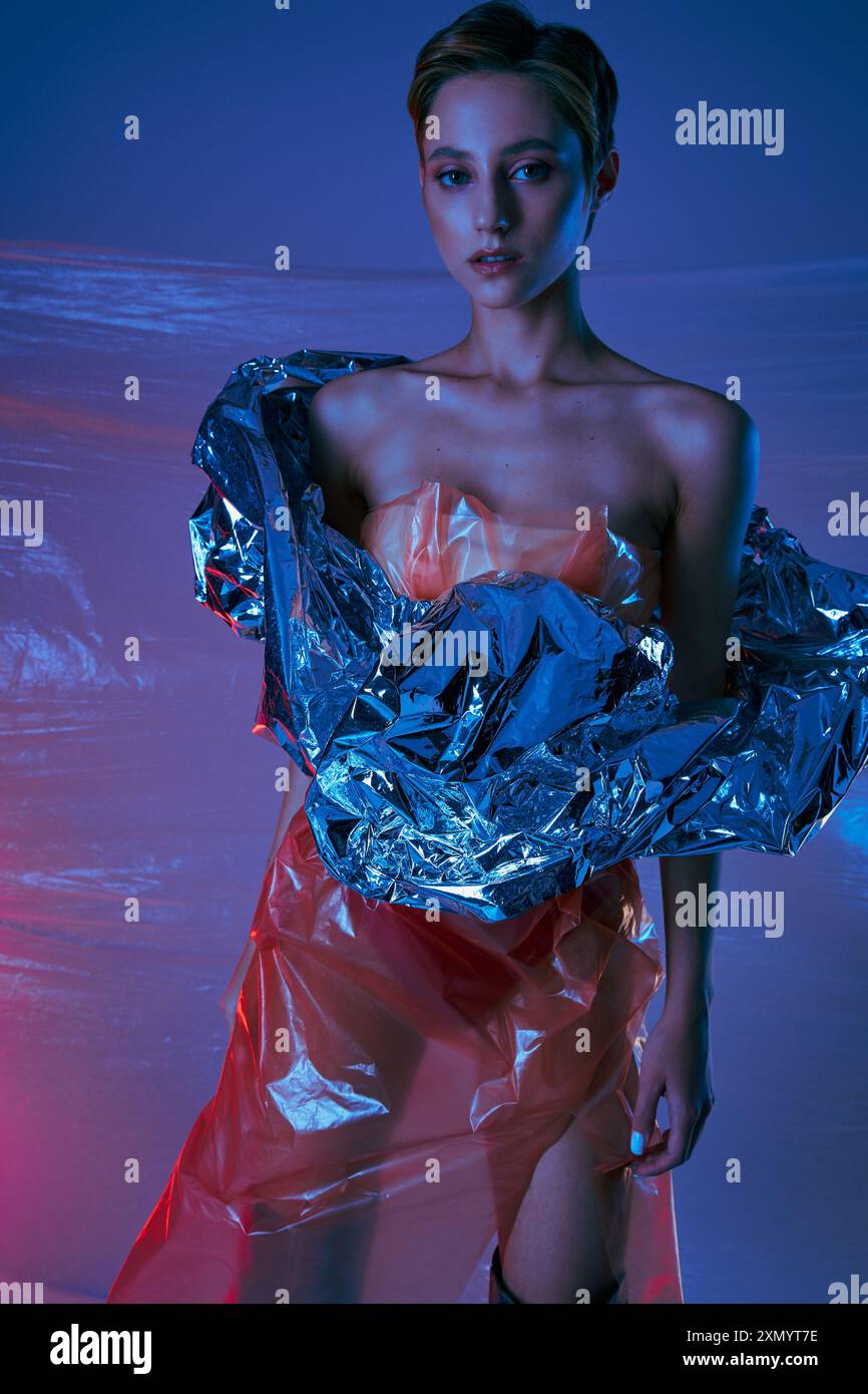 Une femme pose dans un studio, portant une tenue élégante faite de matières plastiques réutilisées. Banque D'Images