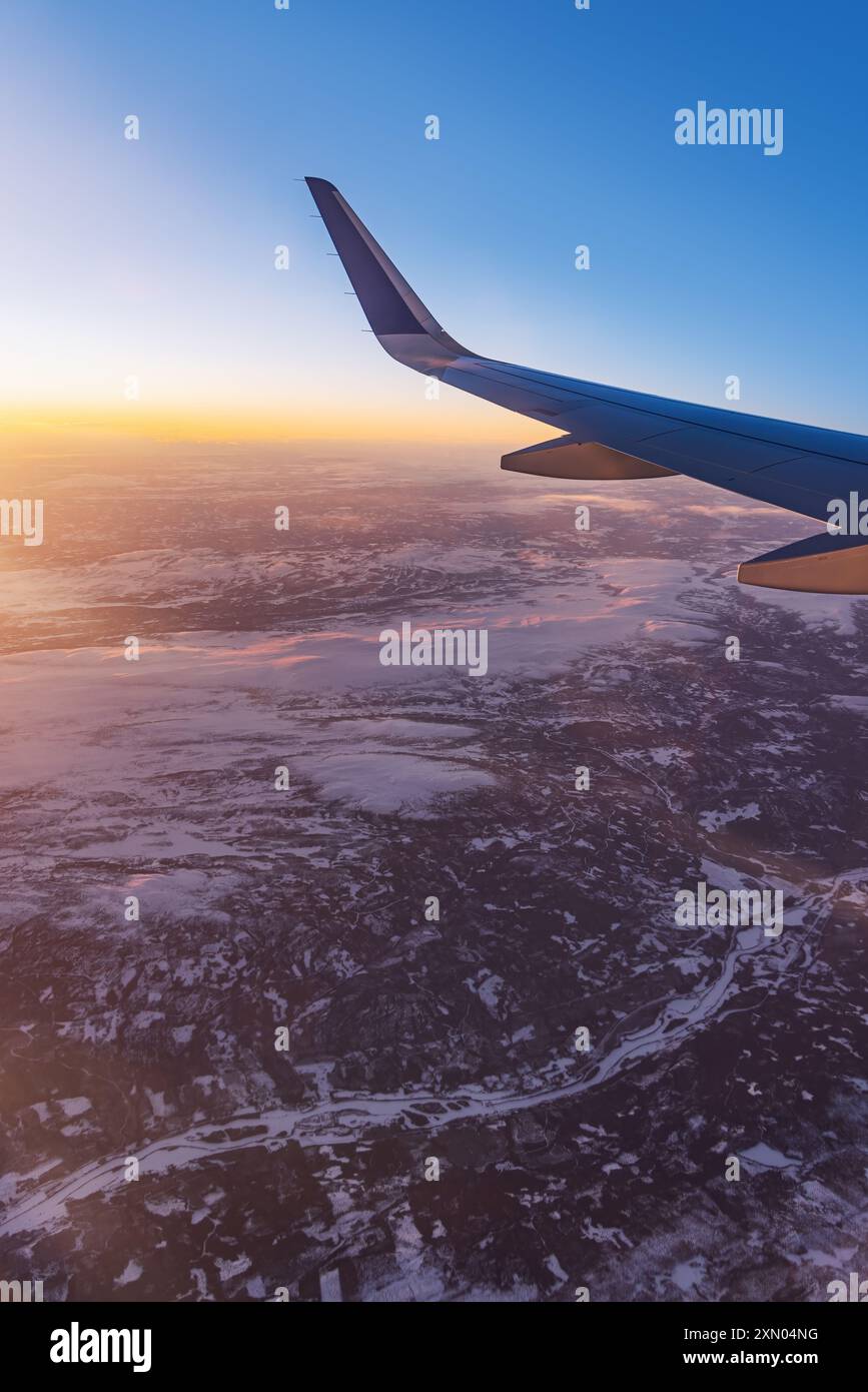 Avion volant bas au-dessus de montagnes enneigées et se préparant à atterrir à l'aéroport, vue depuis la fenêtre de l'avion de la turbine d'aile et de l'horizon Banque D'Images