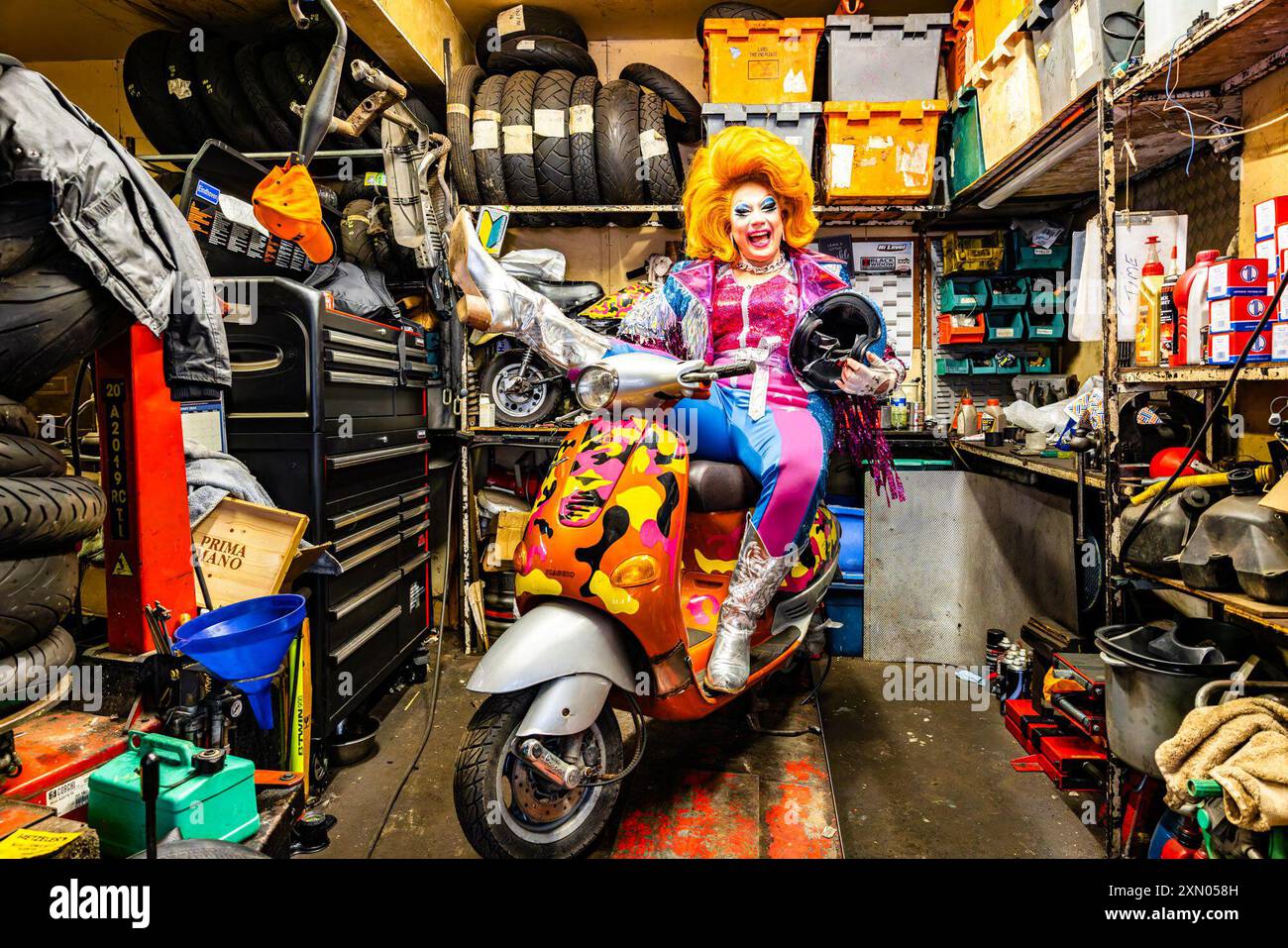 Édimbourg, Royaume-Uni. 30 juillet, 2024 photo : Ginger Johnson chevauche un cyclomoteur coloré dans un atelier de moto. Reine régnante de RuPaul's Drag Race UK, la célèbre performeuse Ginger Johnson, échange sa couronne contre un casque de crash alors qu'elle présente son tout nouveau spectacle Ginger Johnson Blows Off ! Vers Edinburgh Fringe 2024.. Crédit : Rich Dyson/Alamy Live News Banque D'Images