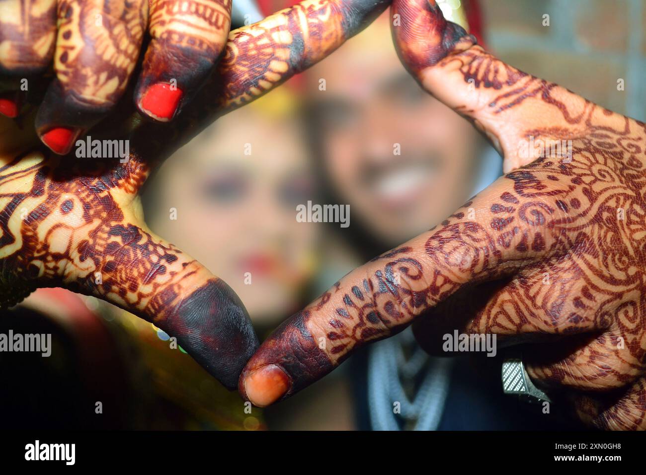 Couple de mariage hindou posant, jeune couple indien souriant avec confiance tout en faisant un geste carré avec les mains Banque D'Images