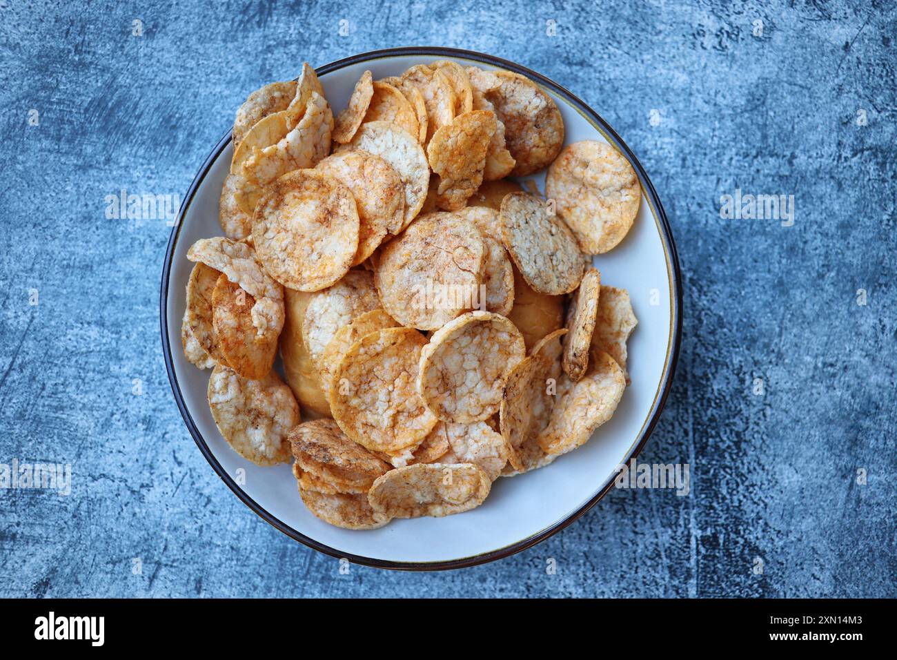 Faire revenir les chips de riz avec les épices et le sel dans un bol Banque D'Images