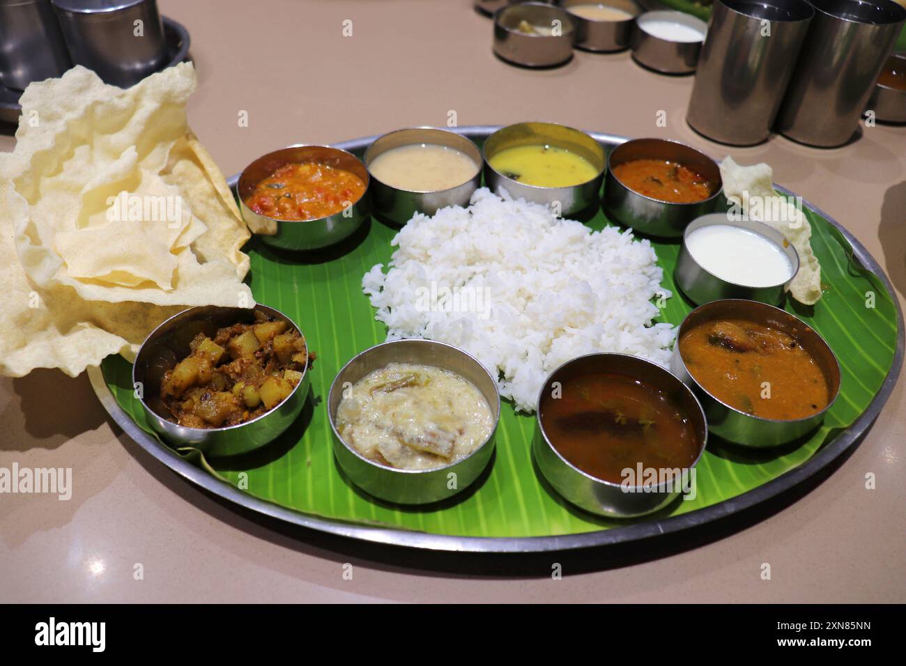 Un thali ou repas sud-indien se compose de riz cuit à la vapeur, sambar, rasam, currys de légumes, Avial, chutney à la noix de coco, cornichons, papadum, caillé ou yaourt Banque D'Images