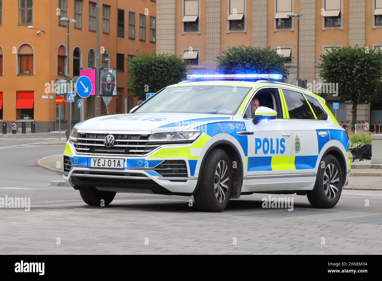 Stockholm, Suède - 29 juillet 2024 : Volkswagen Touareg voiture de police suédoise marquée sur la place Gustav Adolfs avec ses feux de détresse activés. Banque D'Images