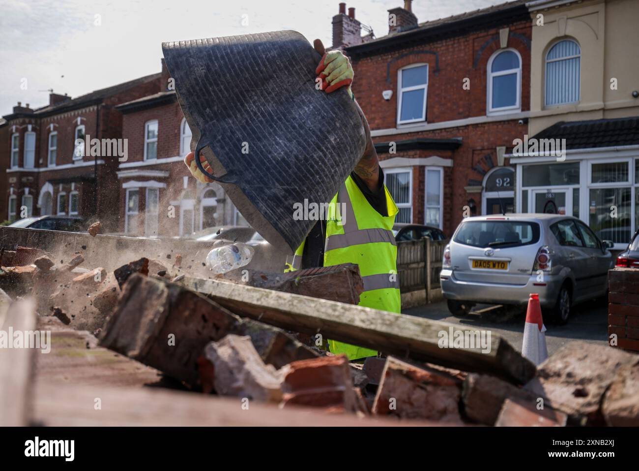 Les débris sont enlevés d'un mur endommagé sur Sussex Road à Southport, Merseyside, après que les policiers ont subi de graves blessures quand des briques, des pierres et des bouteilles ont été lancées et des voitures incendiées lors de violentes manifestations à la suite d'une veillée en faveur de trois filles tuées dans une attaque au couteau dans un club de vacances sur le thème de Taylor Swift lundi. Date de la photo : mercredi 31 juillet 2024. Banque D'Images