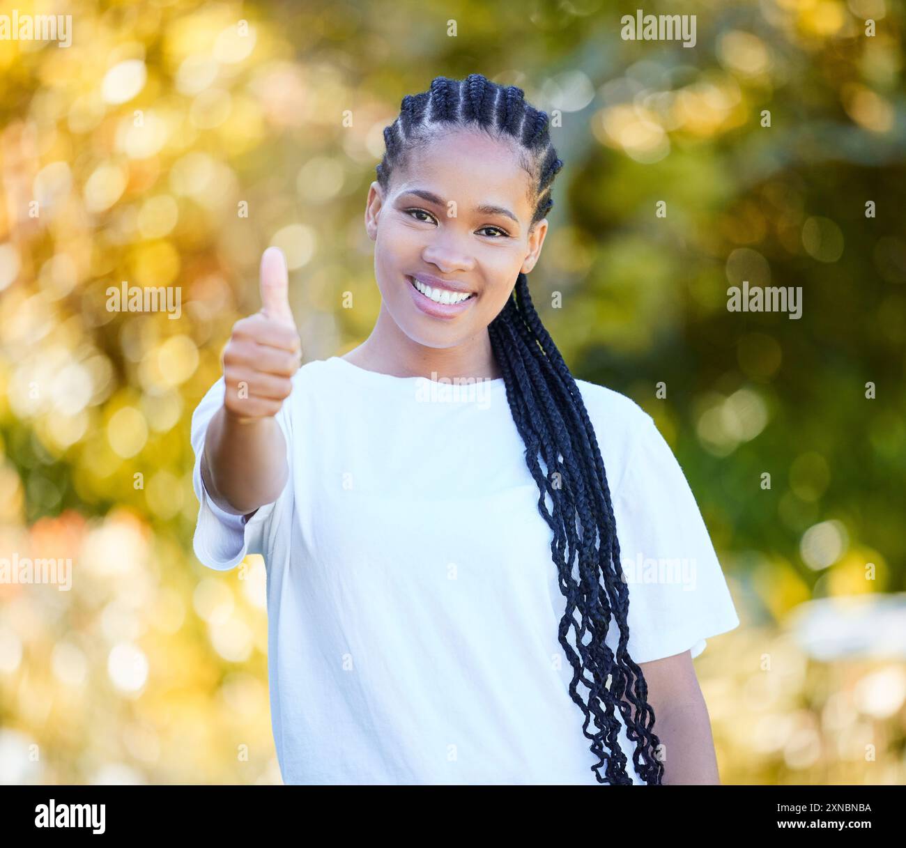 Portrait, femme heureuse et noire avec les pouces vers le haut en plein air pour vous remercier, accord et soutien de la nature. Sourire, personne africaine et votes oui, opinion Banque D'Images