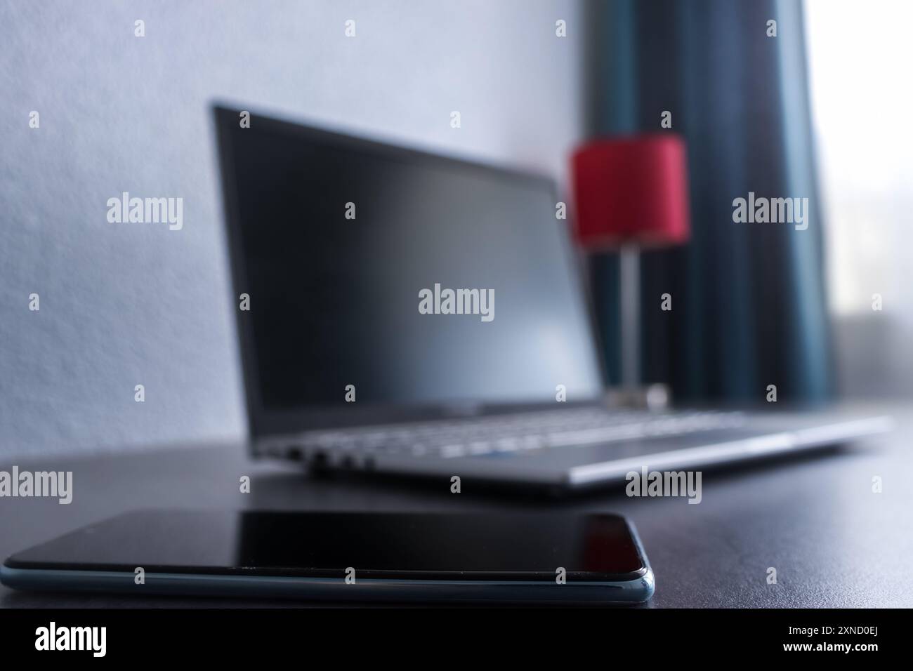 Gros plan d'un téléphone mobile et d'un ordinateur portable dans le bureau à domicile d'un homme d'affaires Banque D'Images