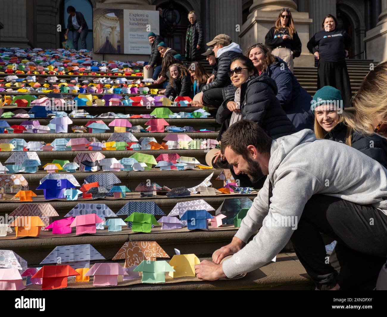 Melbourne, Australie. 31 juillet 2024. Les bénévoles roulent les rangées de maisons en origami après la fin de l'événement. 6 000 maisons en origami ont été placées sur les marches du Parlement de Victoria par le Victorian Homeless Network, symbolisant 10% des maisons sociales nécessaires dans l'État pour mettre fin à l'itinérance. Crédit : SOPA images Limited/Alamy Live News Banque D'Images