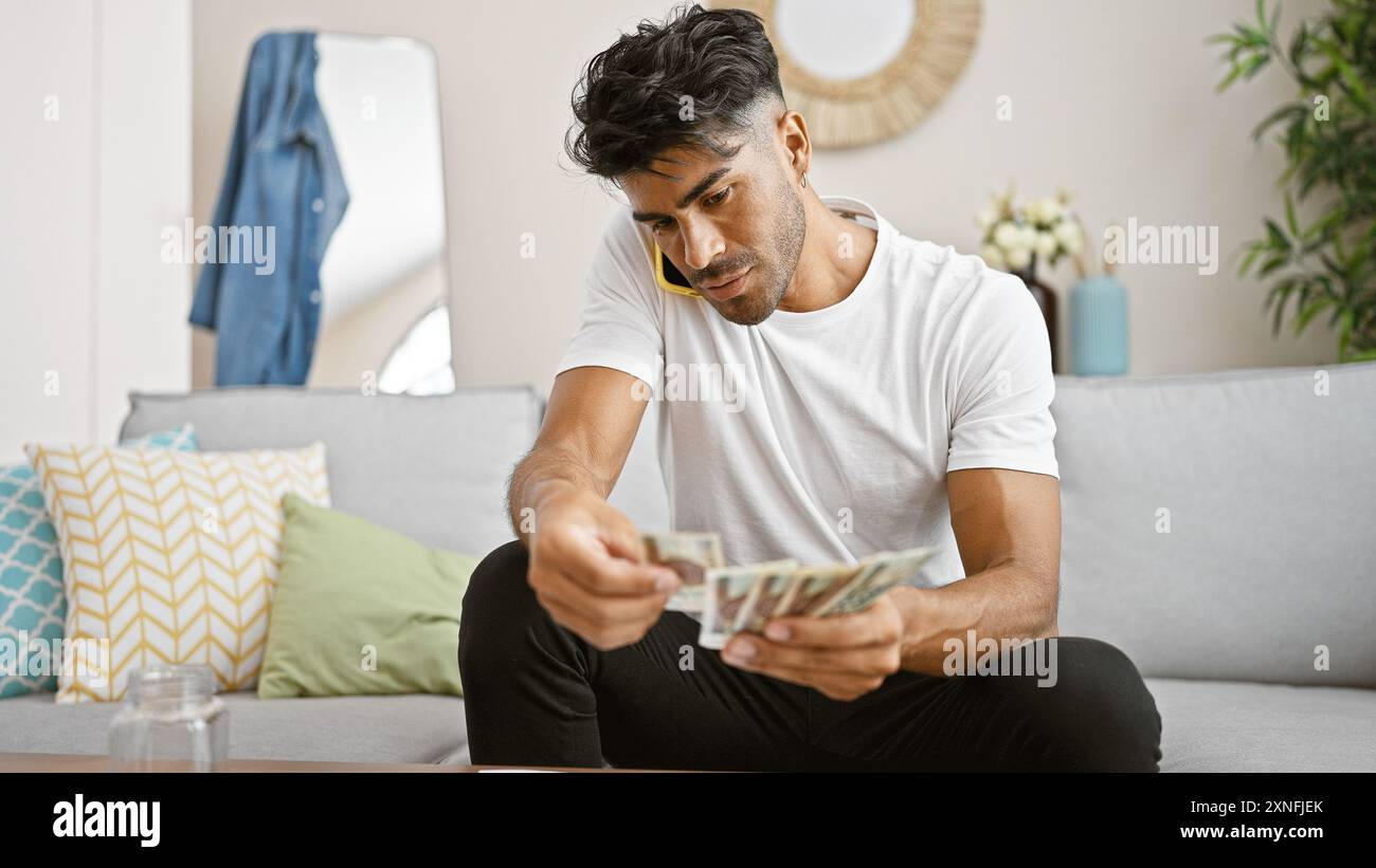 Beau jeune homme comptant des billets de zloty polonais dans un salon moderne. Banque D'Images