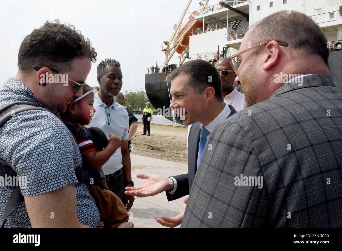 31 juillet 2024, Milwaukee, Wisconsin, États-Unis : PETE BUTTIGIEG, secrétaire du Département des Transports des États-Unis, parle à CAMILLE TINDALL-SCHLICHT, 9 mois, et ses parents AARON TINDALL-SCHLICHT, à gauche, et ADAM TINDALL-SCHLICHT, à droite, alors qu'il visite l'installation de chargement de grain DeLong Co. au port de Milwaukee (Wisconsin) mercredi 31 juillet 2024. Sa visite faisait partie d'une tournée dans trois états du Midwest pour promouvoir la façon dont le programme investir dans l'Amérique de l'administration Biden-Harris a profité à différents segments de l'économie. L'événement a eu lieu à côté du navire amarré basé à Singapour Patagonian Bound fo Banque D'Images