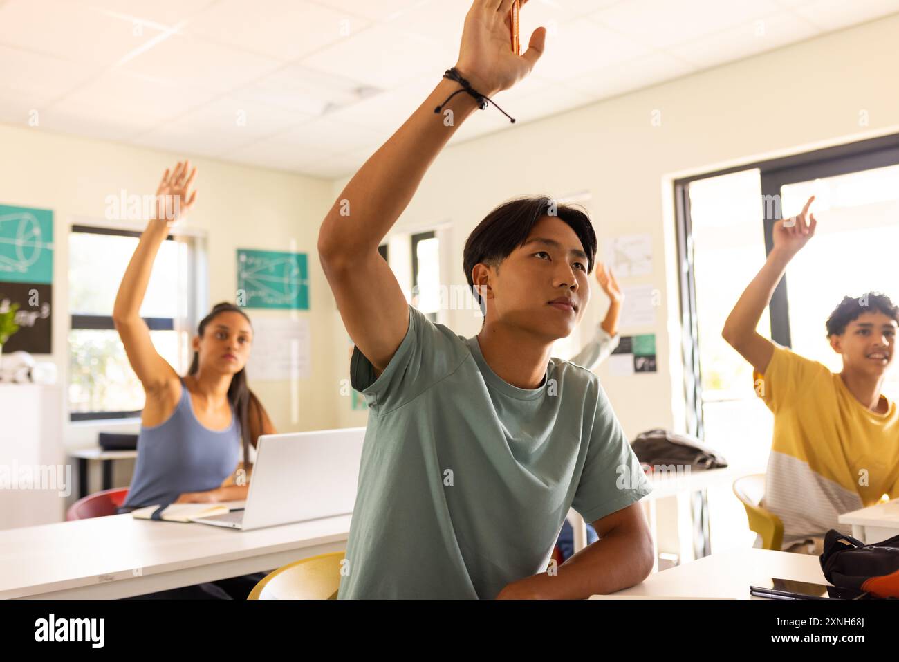 Au lycée, les élèves lèvent la main pour répondre à une question en classe Banque D'Images