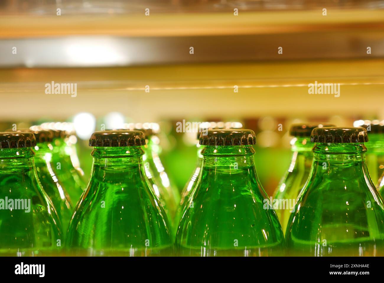 Les bouteilles de boisson vintage avec des bouchons colorés sur l'étagère du bar créent un affichage de boissons rétro nostalgique Banque D'Images