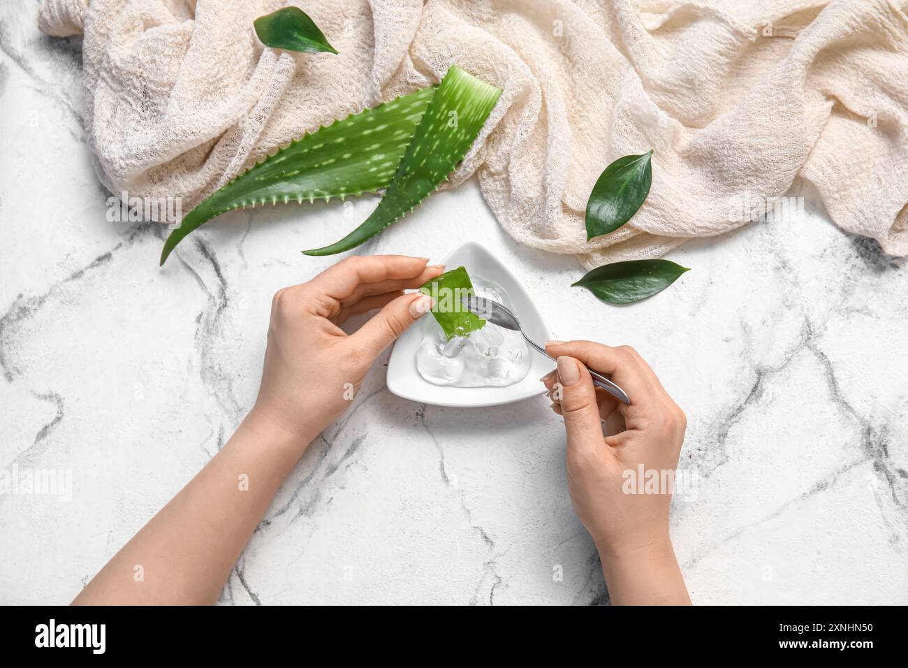 Femme faisant du gel d'aloe vera sur fond blanc Banque D'Images