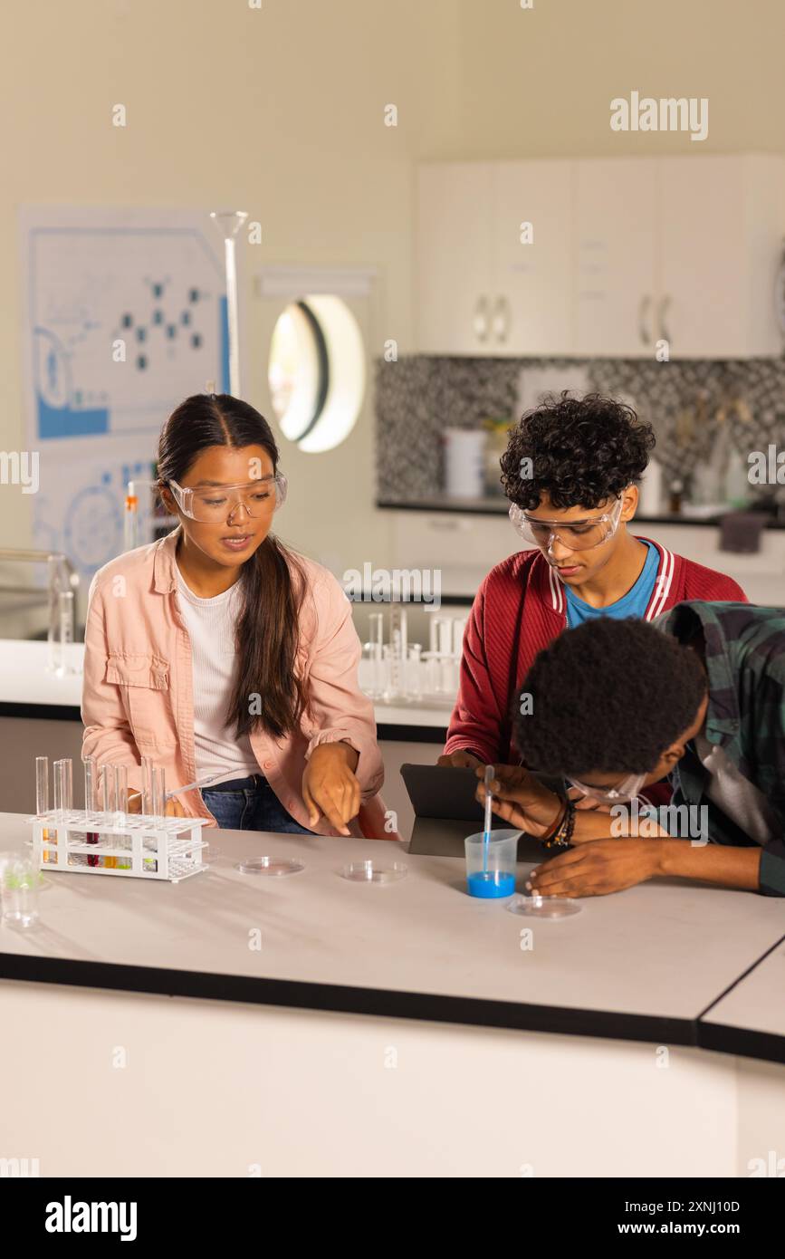 Réalisation d'expériences scientifiques avec des tubes à essai et des comprimés, des étudiants dans le laboratoire du lycée Banque D'Images