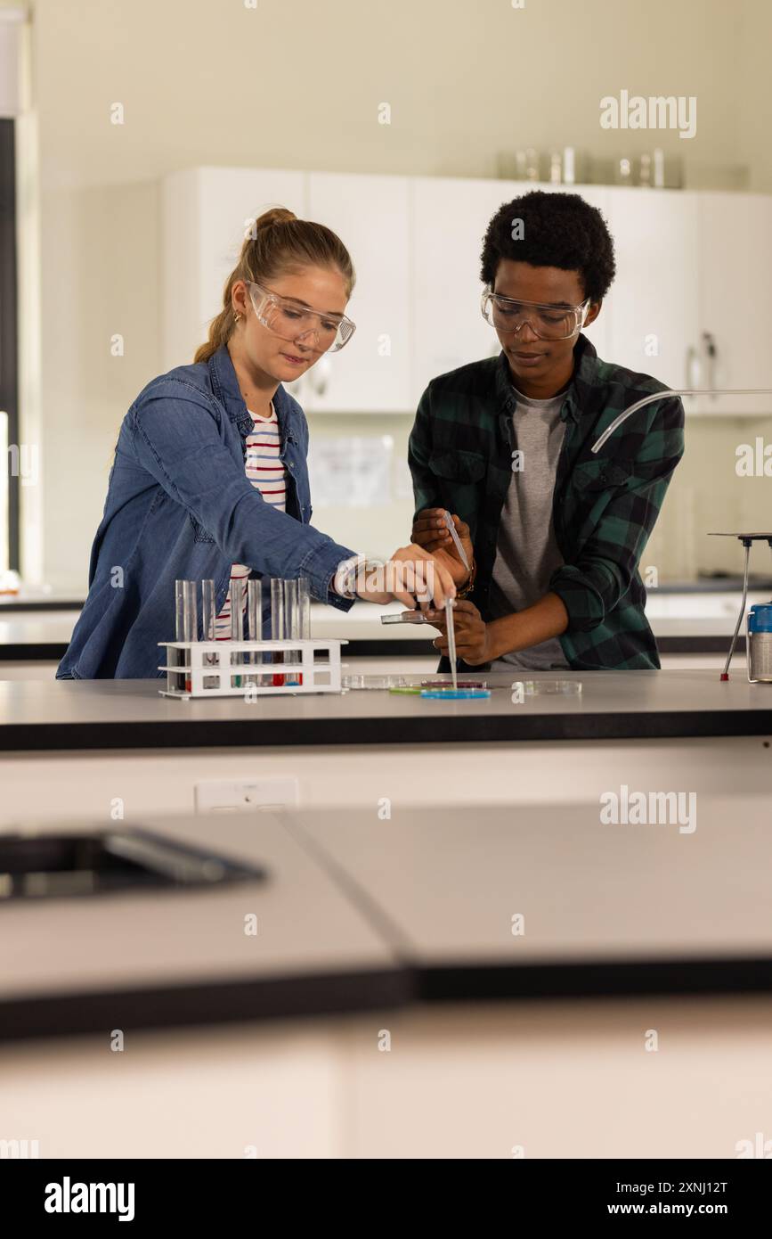 Dans le laboratoire du lycée, les adolescents menant des expériences scientifiques avec des béchers et des tubes à essai Banque D'Images