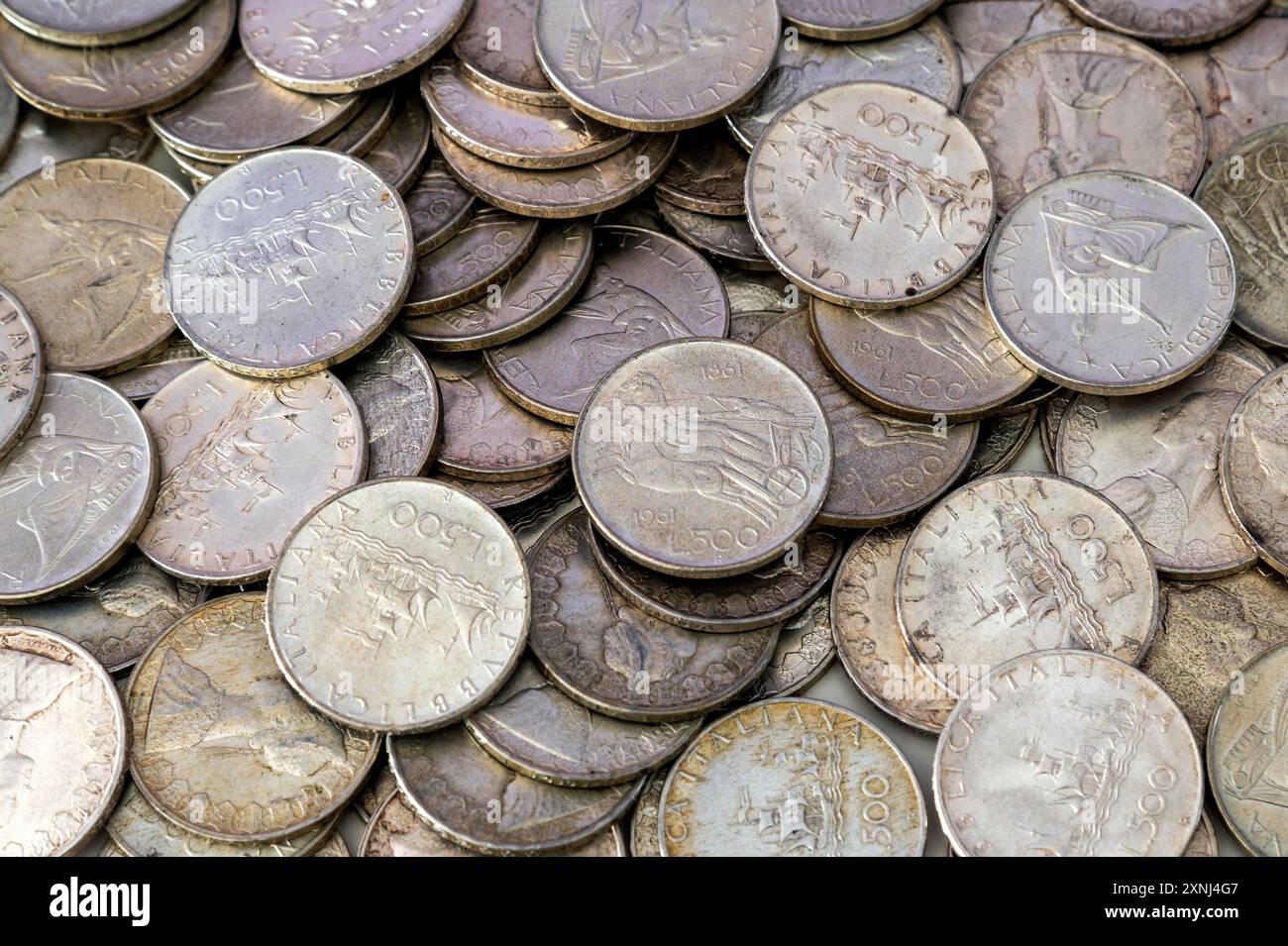 Beaucoup de vieilles monnaies italiennes de 500 lires en argent reposent sur une surface, créant un fond numismatique Banque D'Images