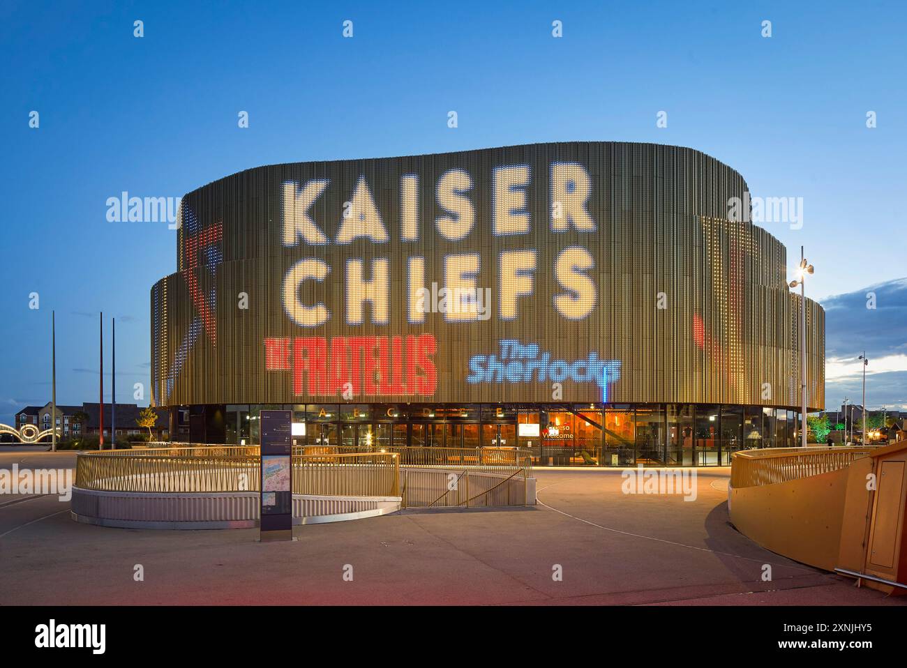 Façade extérieure avec éclairage LED au crépuscule. Swansea Arena et Copr Bay Bridge, Swansea, Royaume-Uni. Architecte : acme, 2024. Banque D'Images